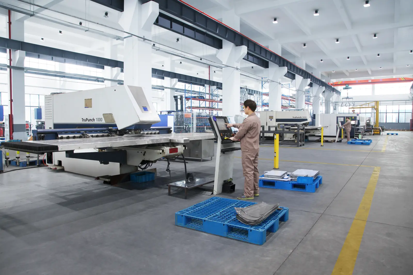 CNC sheet-metal punching equipment and operator in the workshop